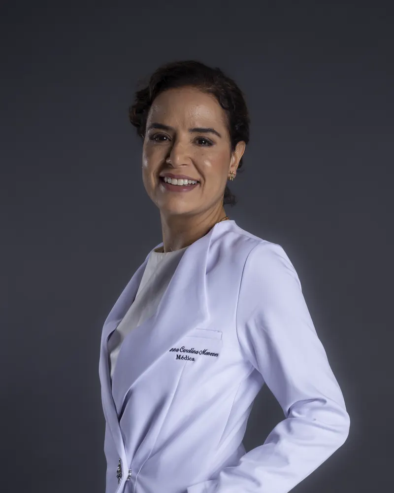 Dra. Anna Carolina Rocha, médica, de jaleco branco, sorrindo