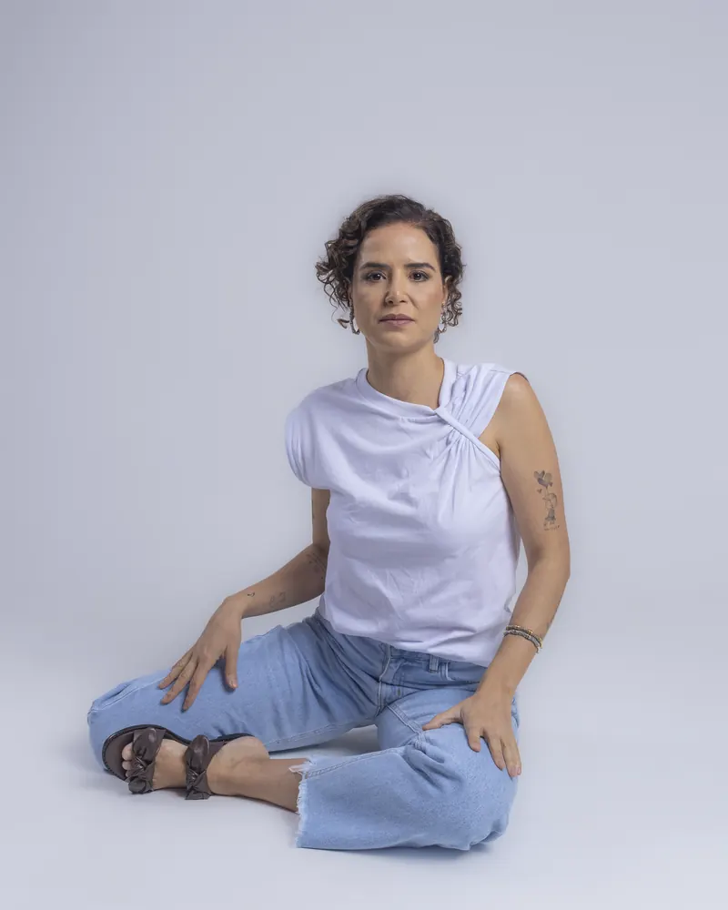Dra. Anna Carolina Rocha sentada, em retrato profissional