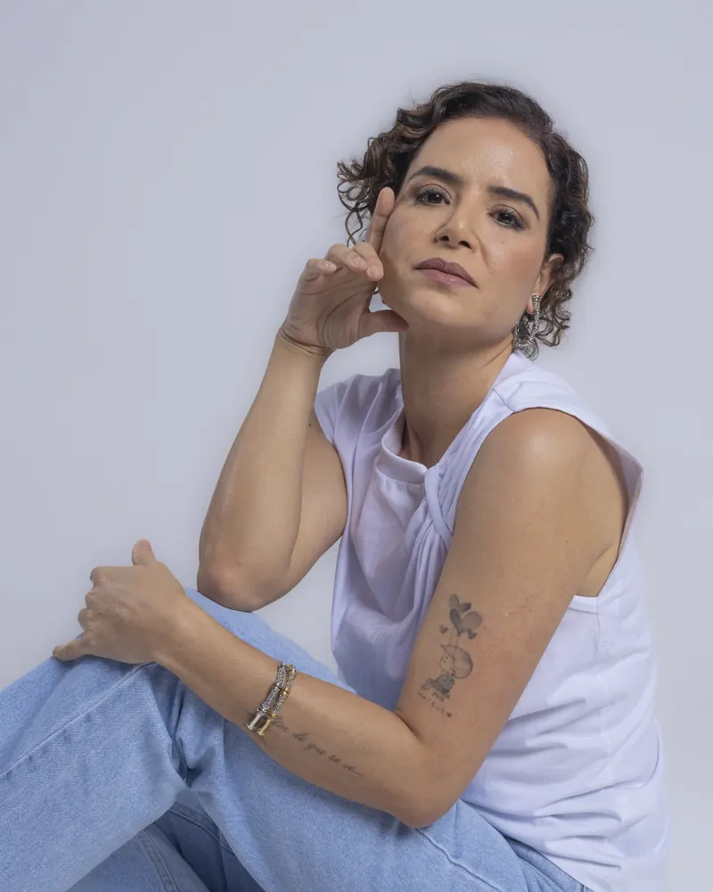 Dra. Anna Carolina Rocha sentada, sorrindo, em retrato profissional